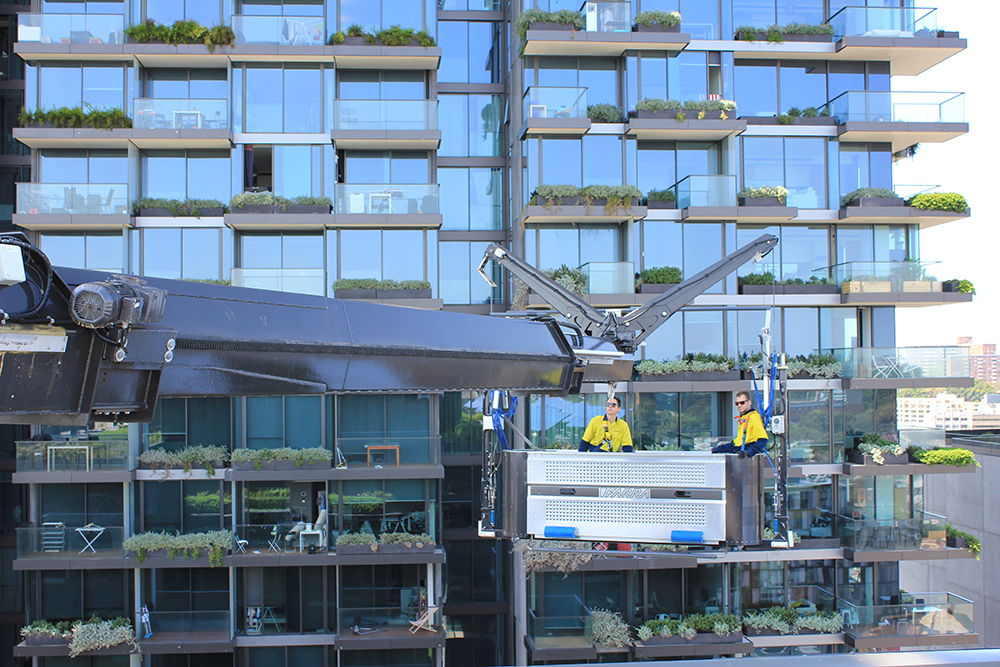 OCP BMU with Gardeners maintaining vegetation in garden boxes and green walls on a glass facade tower