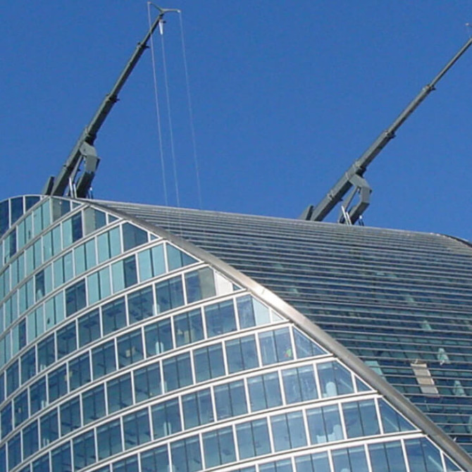 moorehouse bmu access machines in action extended on top of curved glass facade