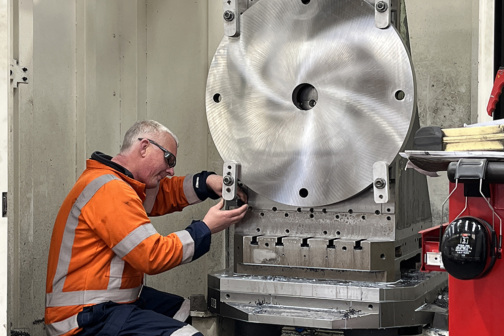 Machinist Steve machining a large metal disk in Mori CNC Pallet machine close up Tile