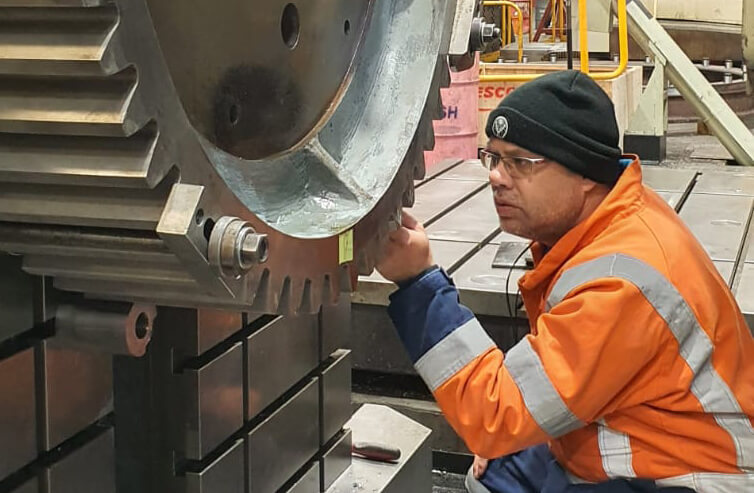 machinist andre checking large cog on the floor borer