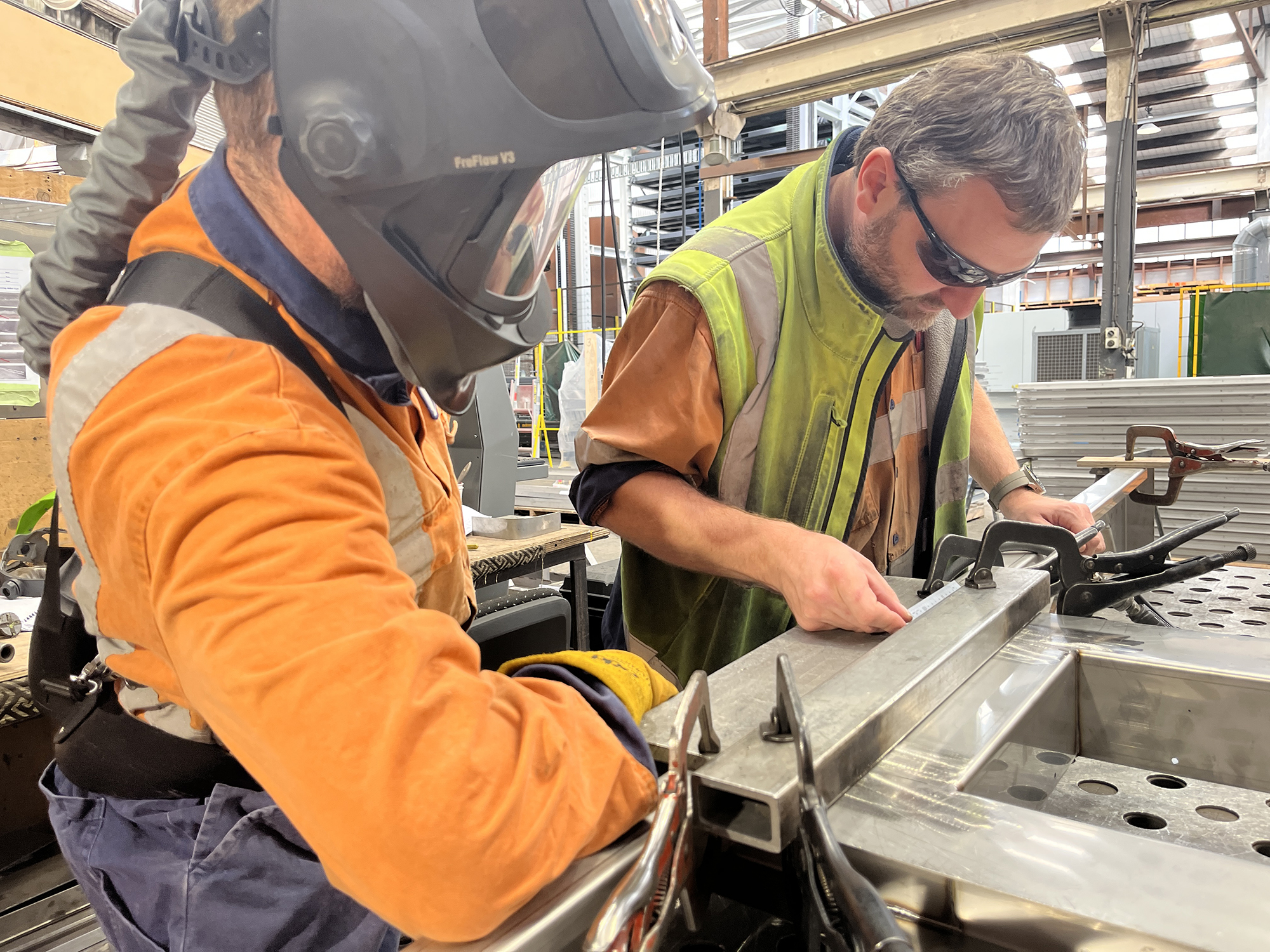 Welder and Weld inspector checking quality of train parts